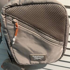 NWT Reebok Ariana Crossbody bag with outside pocket and inside slip pocket.